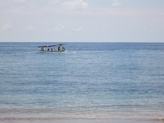 Women navigating a small boat on Lake Michigan under a clear sky.