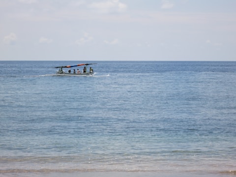 Women navigating a small boat on Lake Michigan under a clear sky.