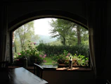 Evening view through a window showing a peaceful garden outside the room