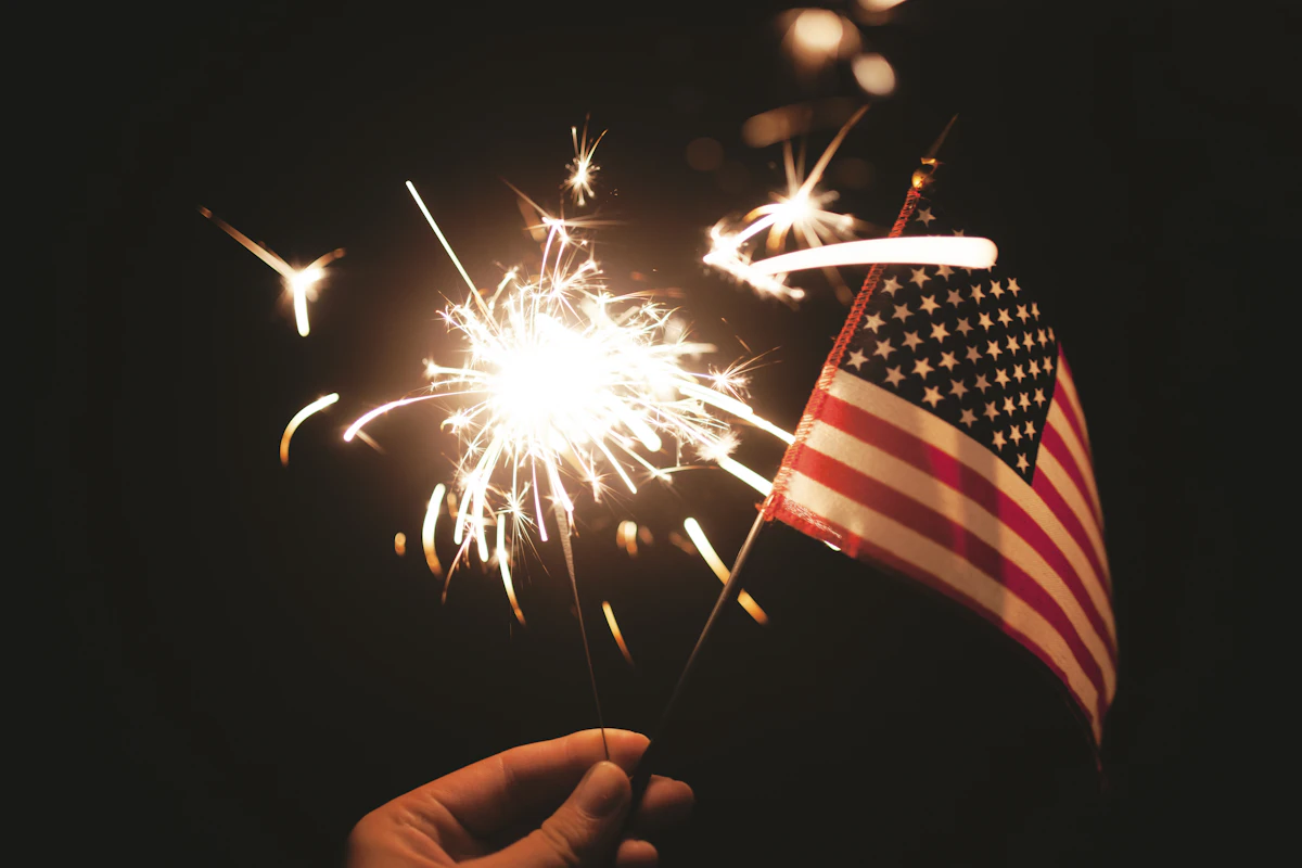 Sparkler and American flag lit up for the Fourth of July
