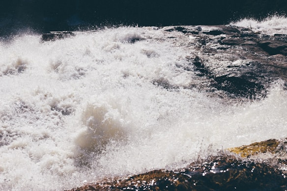 Powerful, churning white water cascading over rocks, creating a sense of intense movement and natural force.