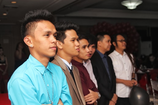 A group of men in formal attire laughing and enjoying a toast at a fraternity gathering.