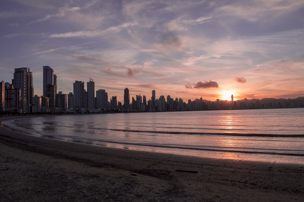 Edificios de la ciudad cerca del agua del océano durante la puesta de sol