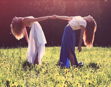 two women bending while holding hands