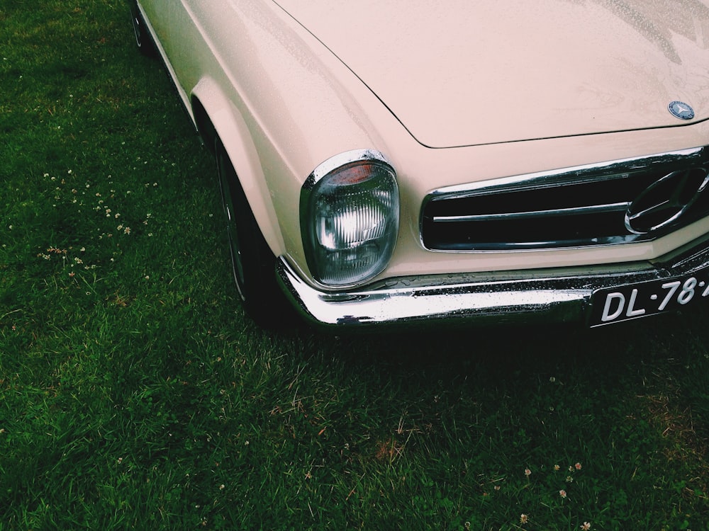 beige car on green grass field