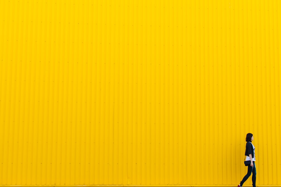 woman wearing black top standing near yellow wall, Yuliia Kutsaieva near yellow wall of supermarket