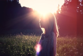 photo of woman on green grass field outdoors during daytime