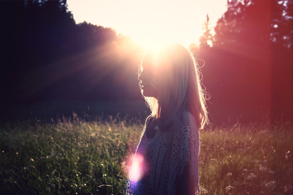 photo of woman on green grass field outdoors during daytime