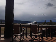 Front porch of a cabin with rocking chairs overlooking the vast Wyoming wilderness.