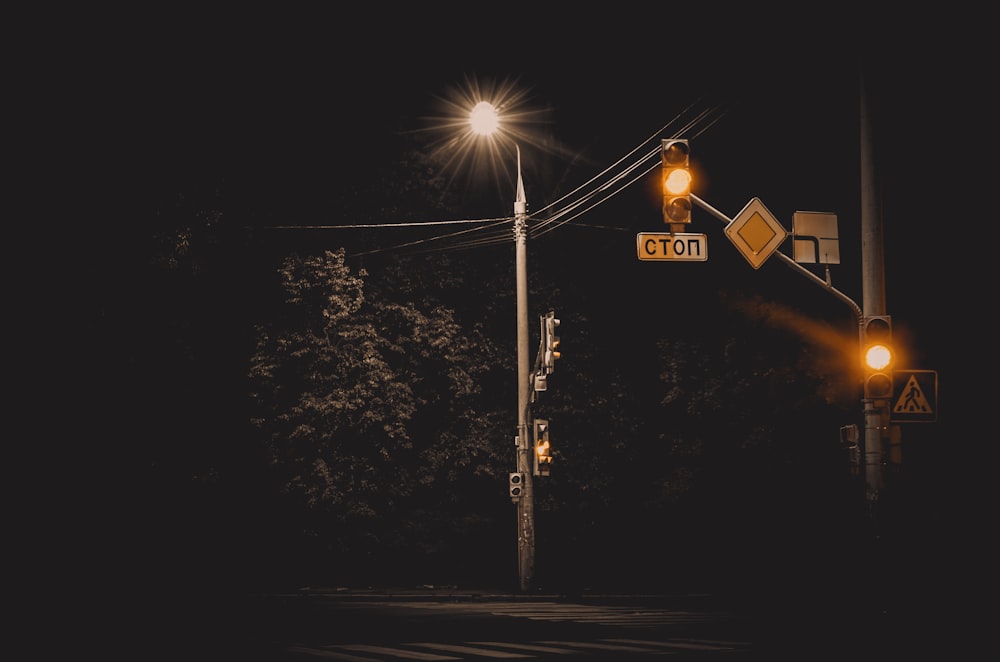 gray street post near green trees during nighttime