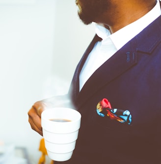 man holding white ceramic mug with coffee