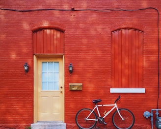 white bicycle parked beside wall