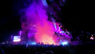 A lively outdoor concert scene with Retroriff performing in front of classic cars under string lights at dusk.