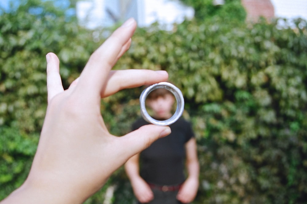 a person holding a ring in front of their face