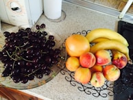 A bowl of fresh fruits and vegetables on a kitchen counter.