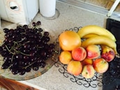 Fresh fruits and a water bottle on a clean, modern kitchen counter.
