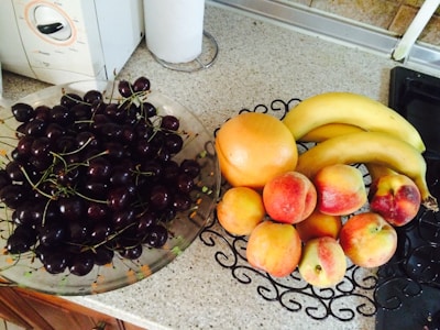 A bowl of organic fruits arranged beautifully on a kitchen counter.
