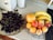 A bright kitchen counter displaying a colorful assortment of fresh fruits and vegetables in bowls.