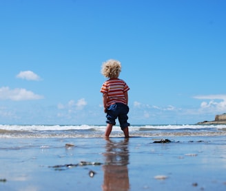 child standing on body of water