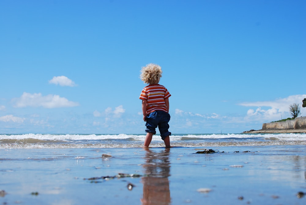 child standing on body of water