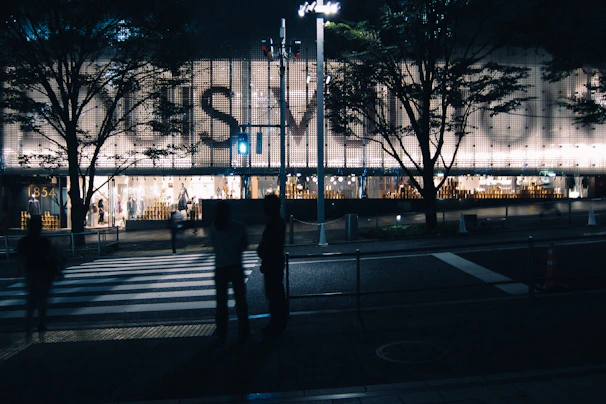 Nighttime scene with an LED totem banner illuminating a retail store entrance