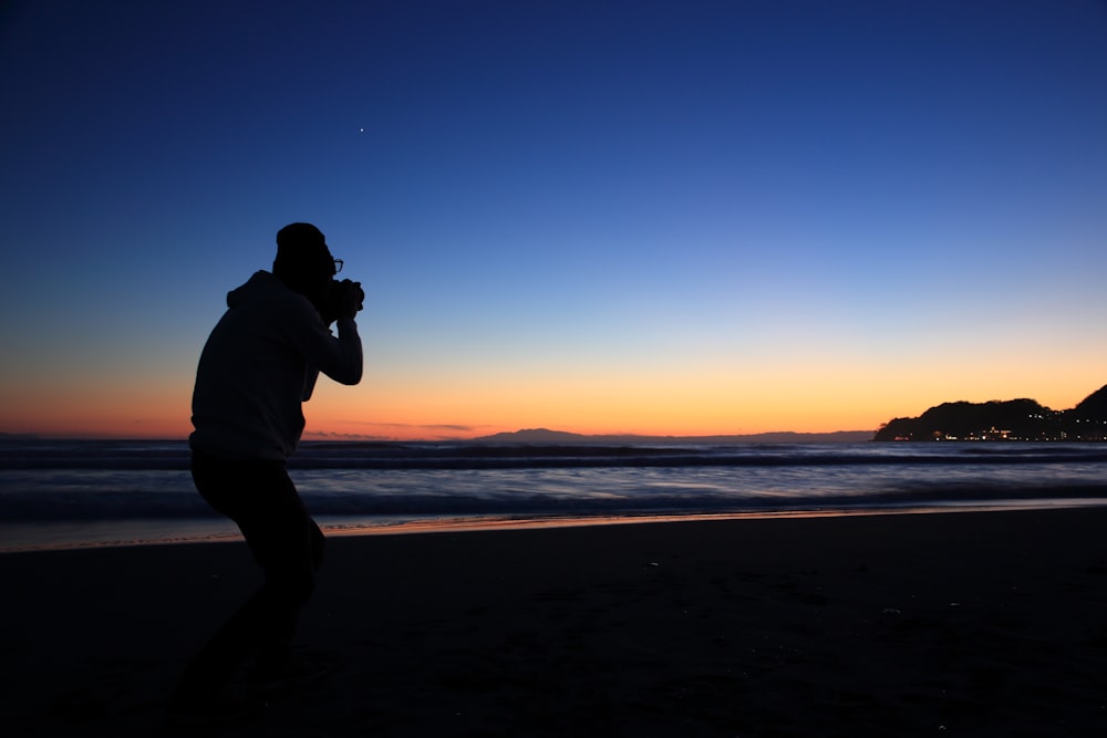silhouette of person standing near seashore