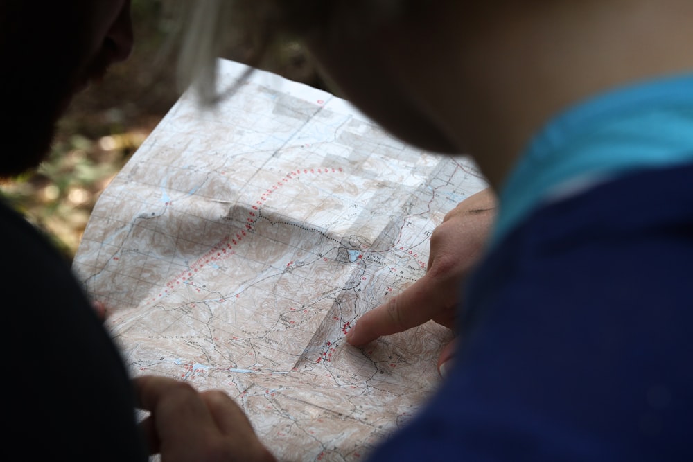 person pointing on beige map