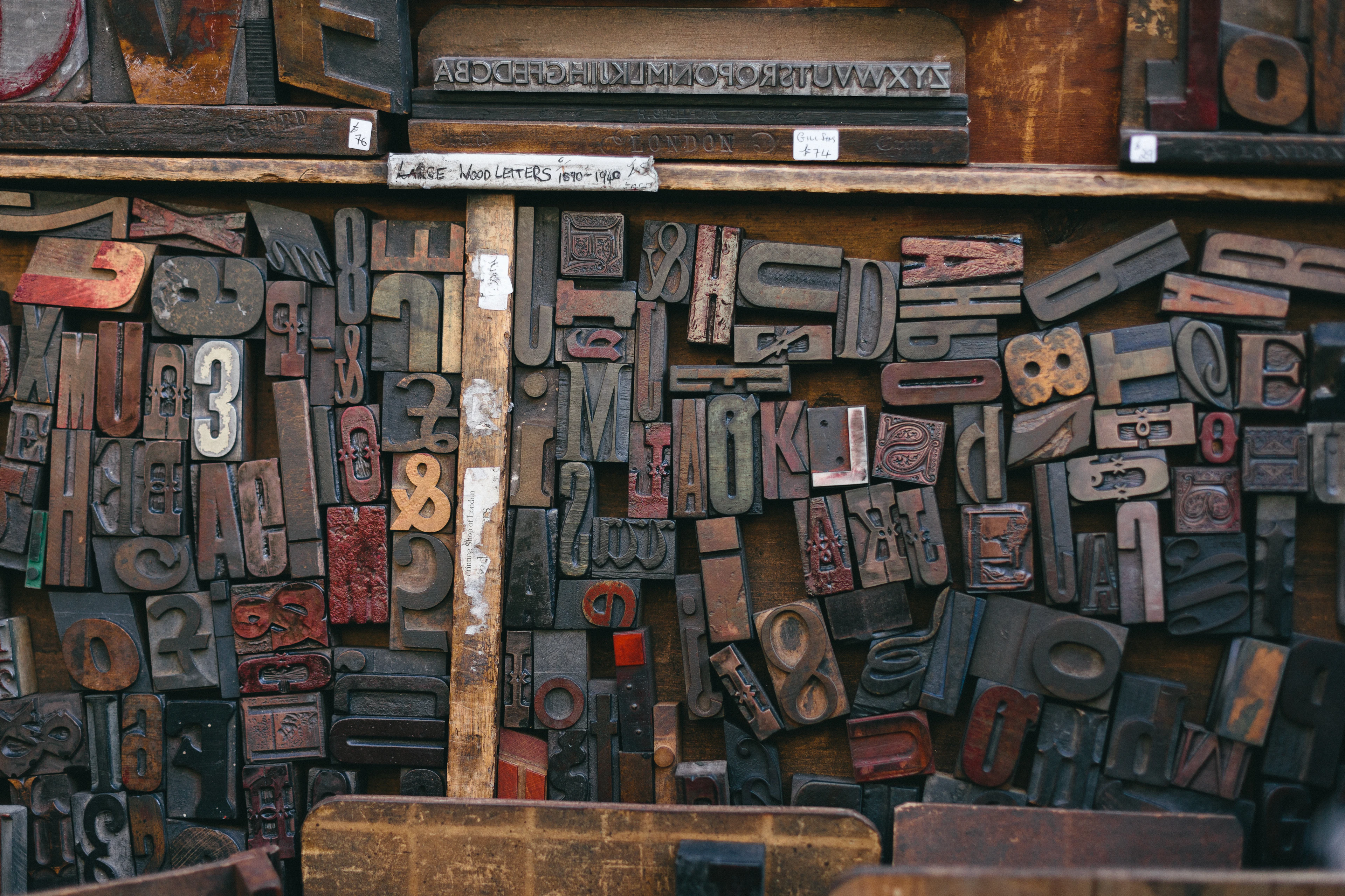 Shelves and drawers crowded with old wooden letterpress type blocks of different sizes and colors