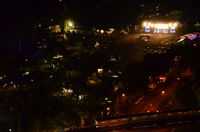 Wide aerial shot of a large outdoor festival with crowds and stages.