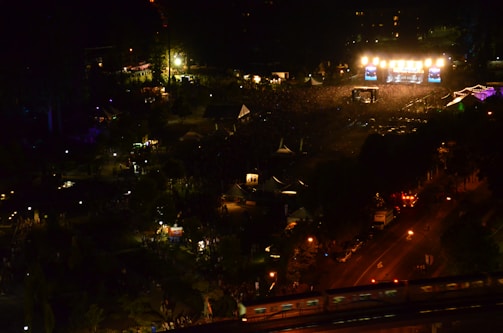 An aerial drone view of a vibrant outdoor festival, showcasing the crowd and stage from above.