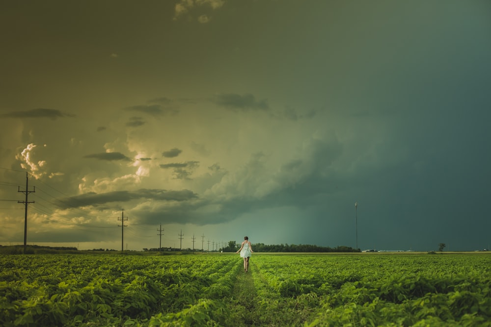 person walking near electric post under cloudy sky