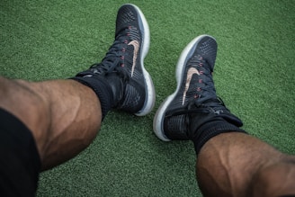 man wearing pair of black Nike shoes