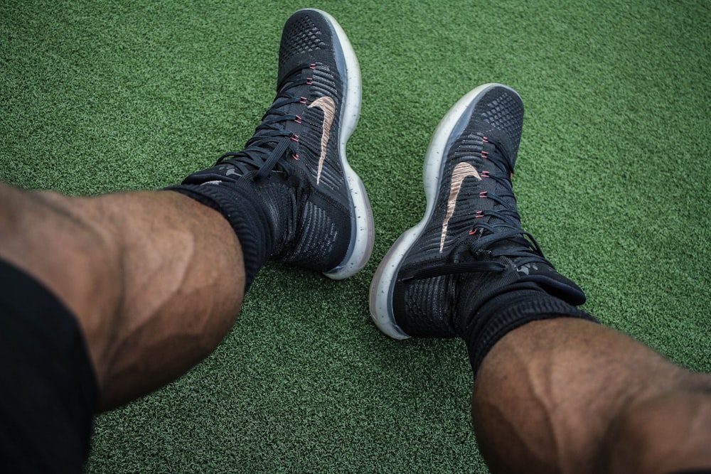 Mann trägt ein Paar schwarze Nike-Schuhe