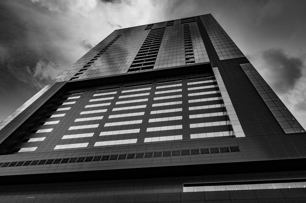 low angle and grayscale photo of high-rise building