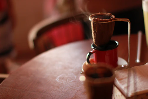 Freshly ground coffee being brewed in a rustic kitchen setting.