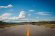 An open road stretching into the horizon under a clear blue sky.