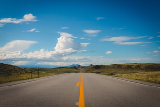 An open road stretching into the horizon under a clear sky.