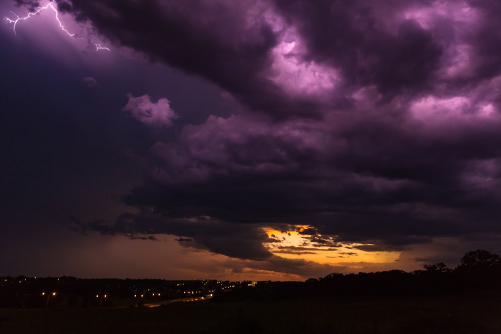 city at night under purple and orange cloudy sky