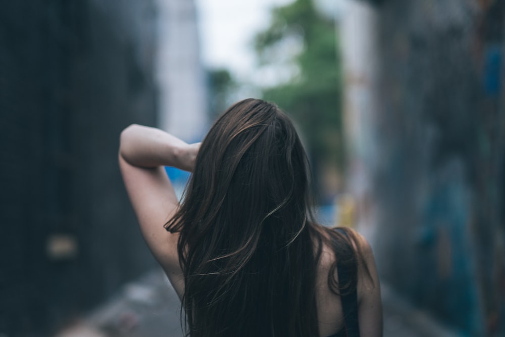 Photographie sélective de mise au point d’une femme ondulant ses cheveux