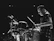 A focused teen expertly playing a snare drum under bright stage lights.