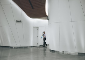 man cleaning on floor beside white wall