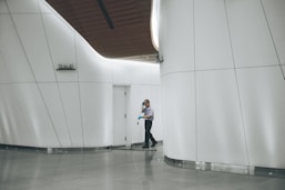 man cleaning on floor beside white wall