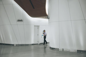 man cleaning on floor beside white wall