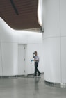 man cleaning on floor beside white wall