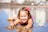 A smiling girl playing in Bunny Bees outfit at the beach.
