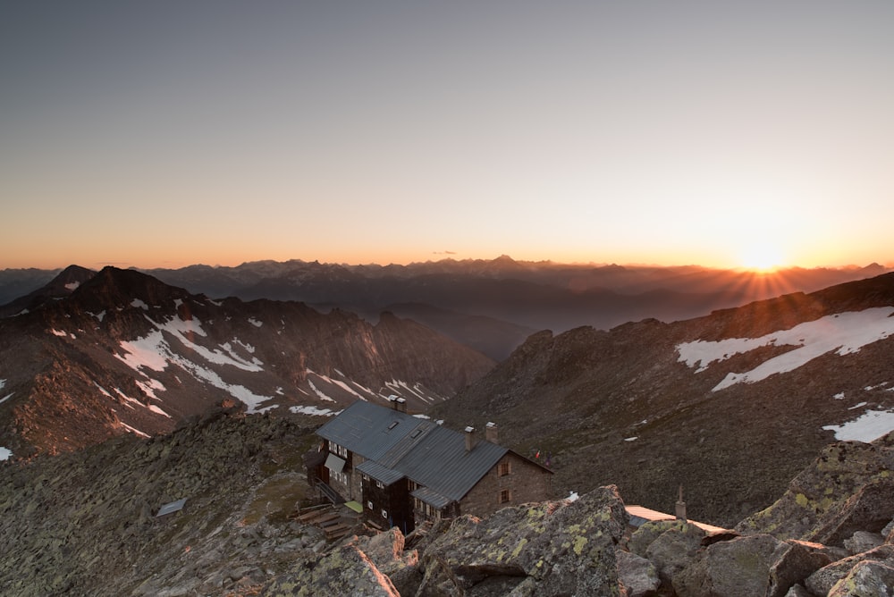 aerial photography of house and snow covered mountain at golden hour