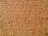 Close-up of a cork coaster under glass with natural wood grain visible.