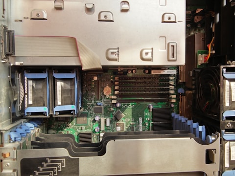 A detailed view of a server's internal components, including multiple RAM slots, visible circuit boards, and several connected hardware elements like hard drive bays and cooling fans. The interior is organized with cables and components aligned neatly inside the chassis.