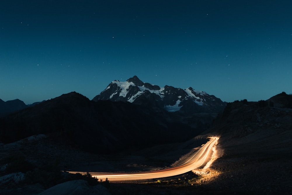 snow covered mountain under blue nightime sky