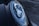 Close-up of a car's headlight featuring a sleek, modern design with intricate reflective components. The surface of the headlight showcases sharp lines and a glossy finish. The surrounding body of the car is dark and polished, contributing to a luxurious vibe.